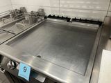 a stainless steel stove top in a commercial kitchen