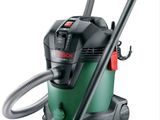 un aspirateur vert et noir muni d'un tuyau, sur fond blanc