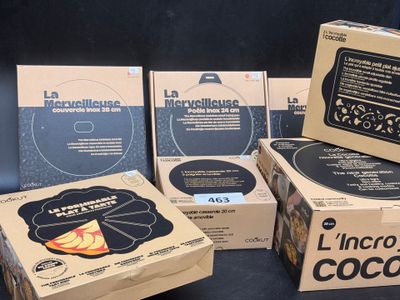 Plusieurs cartons contenant du matériel électronique sont empilés sur une surface noire
