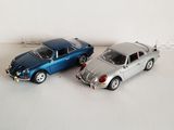 two toy cars sitting next to each other on a white surface