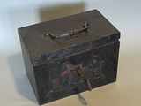 a small metal box with a handle on a table