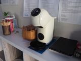 a coffee maker sitting on top of a counter next to a laptop