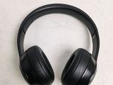 a pair of black headphones sitting on a white surface