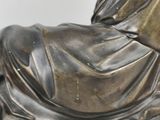 a statue of a woman laying down on a pillow