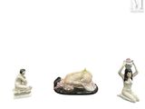 trois figurines représentant une femme et un homme assis par terre