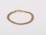 a gold bracelet on a white background