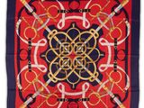a close up of a red and blue square scarf with a gold and black design