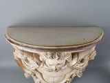 an image of a white table with a carved top on a gray wall