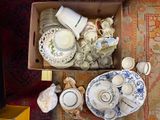 a box full of dishes and cups on the floor