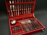 un coffret rouge contenant de l'argenterie, sur fond noir