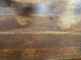 a close up view of a wooden floor with peeling paint on it