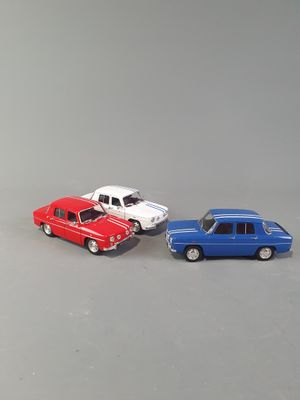 three toy cars sitting next to each other on a table