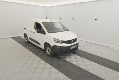 La camionnette blanche est garée dans le garage de l'immeuble.