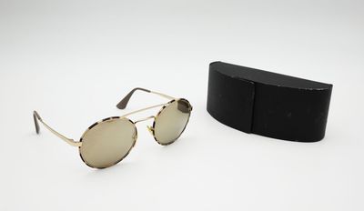 une paire de lunettes de soleil posée sur une boîte noire