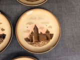 four plates with a picture of a castle on them on a table