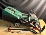 a green lawn mower sitting on top of a wooden table