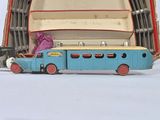 a blue toy truck and a blue toy truck in front of a large open suitcase