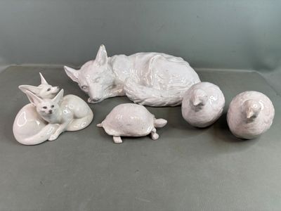 une figurine blanche représentant un chat, une tortue et une balle
