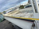 a white truck with a yellow tape on the back of it