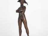 a bronze statue of a man with a hat on his head
