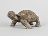an old figurine of a tortoise on a white background