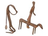 two metal sculptures of a man sitting on a bench next to a dog