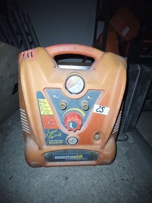 un compresseur d'air orange et noir posé sur un sol en béton