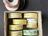 Plusieurs rouleaux de ruban adhésif se trouvent dans une boîte posée sur une table