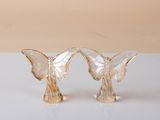 pair of glass butterfly figurines sitting on a white surface