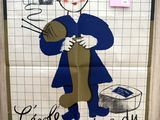 affiche accrochée au mur d'une salle de bains, représentant une femme tenant des aiguilles à tricoter