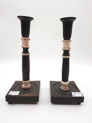 pair of black and gold candlesticks on wooden bases