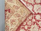 a close up of a red and white rug on a white surface