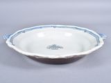 a white bowl with blue trim sitting on a table