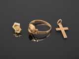 three gold rings and a cross on a black surface