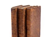 two old books sitting on top of each other on a white surface