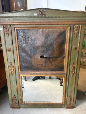 a mirror that is sitting on the floor in front of a cabinet