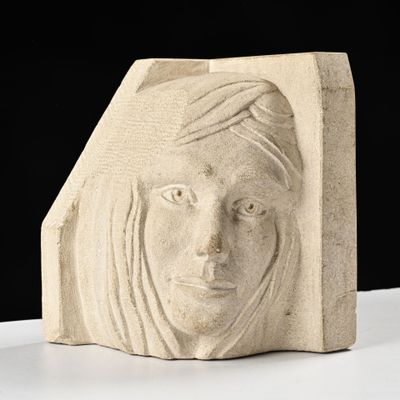 une sculpture représentant le visage d'une femme sur un bloc