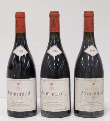 three bottles of red wine are lined up on a white surface