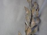 a metal sculpture of a leaf on a table