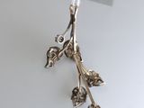 a silver object hanging from a string on a white table