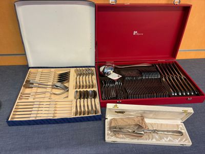 un coffret rouge contenant de l'argenterie sur une table