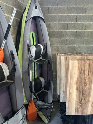 Plusieurs kayaks sont alignés contre un mur de briques dans un garage