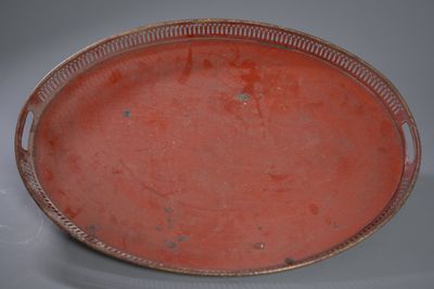 a red plate with a silver rim on a white table