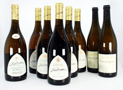 six bottles of wine are lined up in a row on a white surface