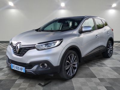 une voiture argentée est garée dans une pièce au sol en damier