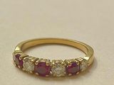 un gros plan sur une bague en or jaune sertie de pierres roses et blanches