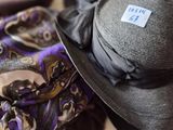 a hat and scarf on a bed next to a pair of shoes