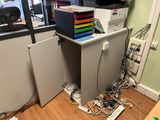 a computer desk with a lot of wires on top of it