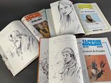 several books of comics are lined up on a table