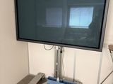 un téléviseur à écran plat posé sur un support dans une pièce